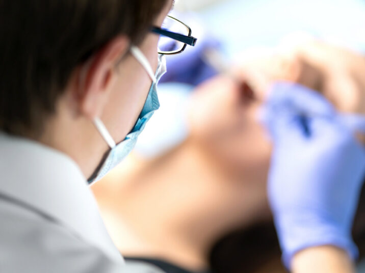 Dentist or dental hygienist in operation with patient. Woman with calculus or caries. Oral doctor removing wisdom teeth. Dentistry. Specialist operating.