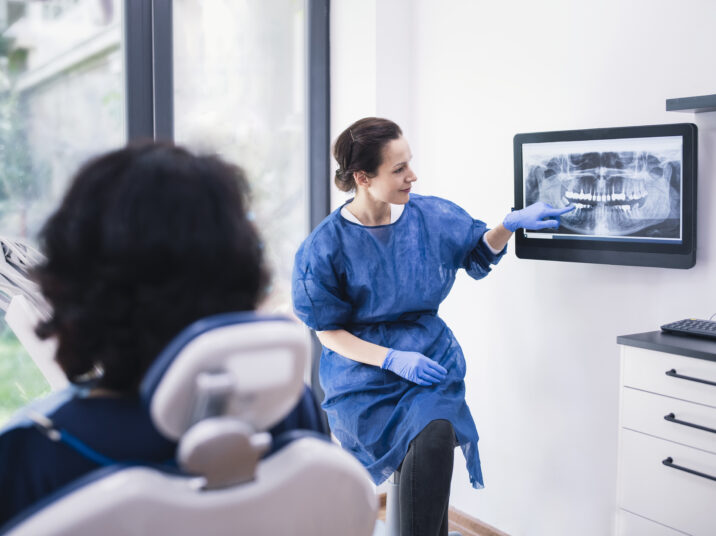 Dentist Explaining Tooth X-Rays To A Patient.
