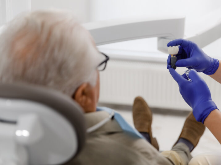 Oral care treatment for a old man patient came for a visit to the dentist he laying down on the dentist chair and have a checkup the doctor using medical instruments for treatment
