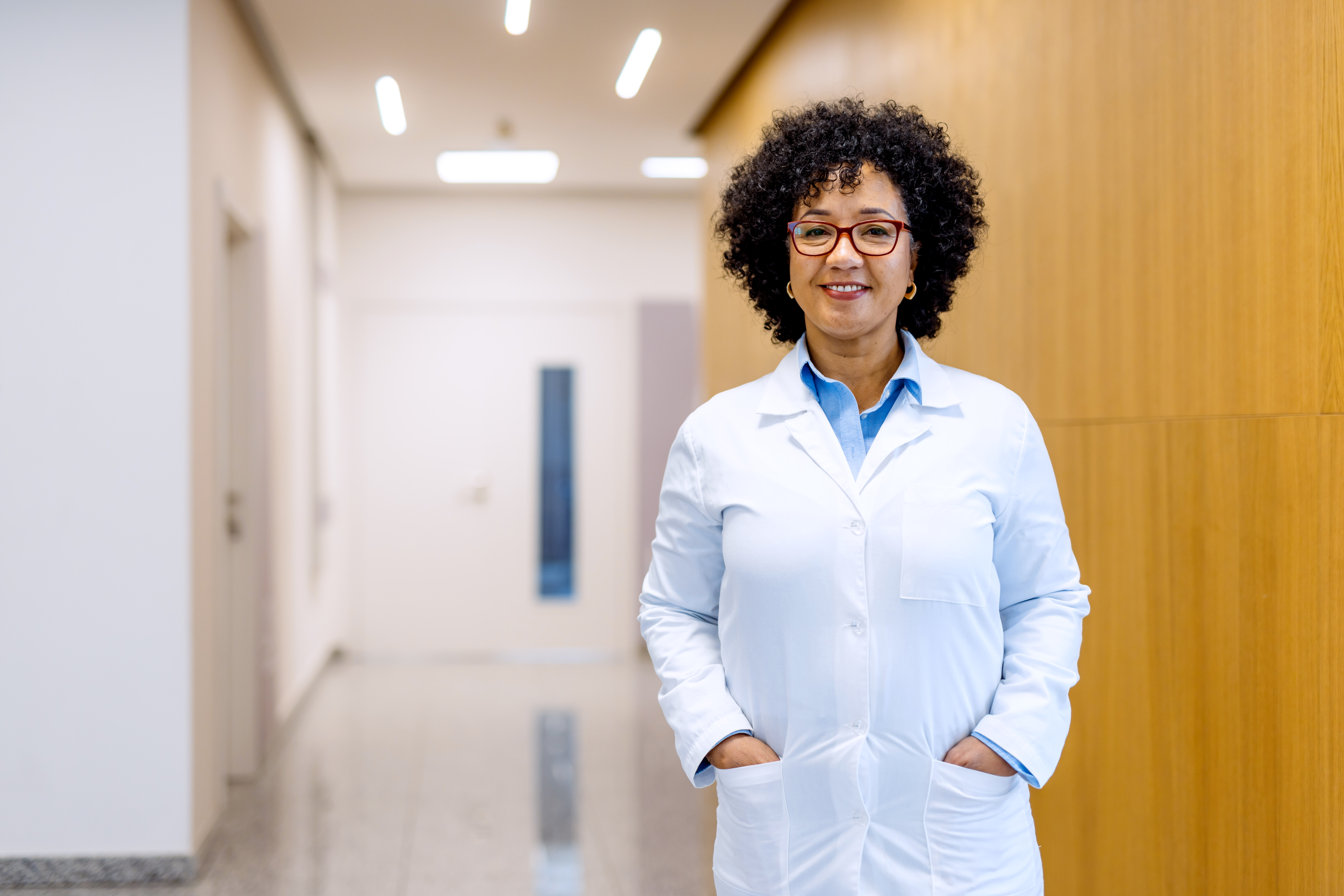 Mature female doctor smiling in hospital corridor