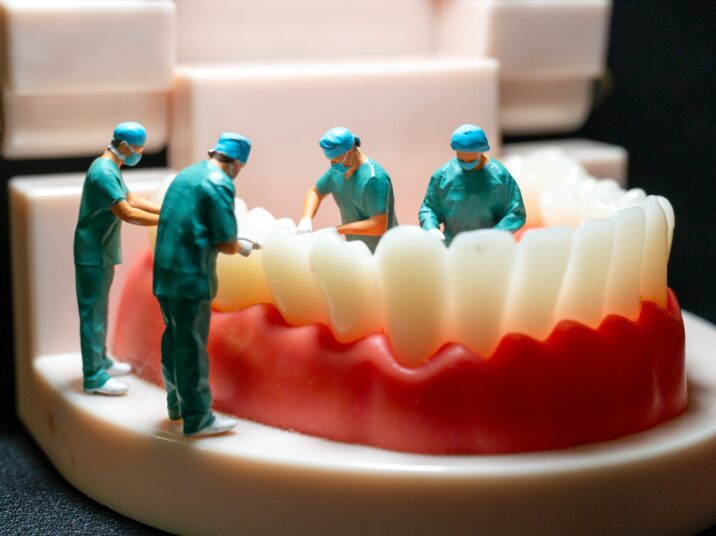 Miniature,Figurines,Of,Surgeons,Working,On,A,Large,Model,Of