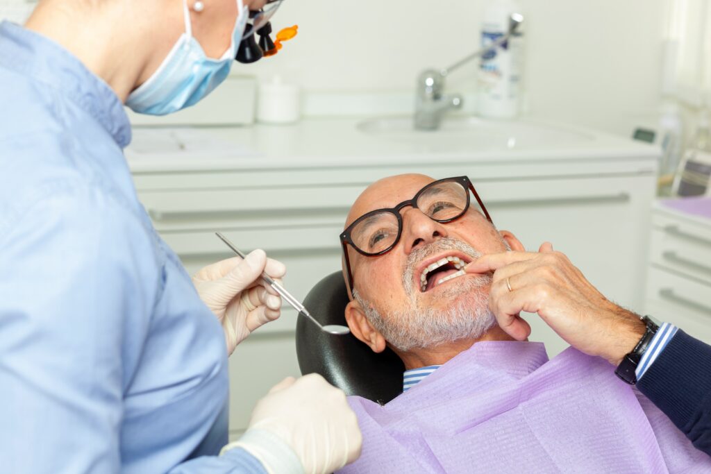 Dentist,Wearing,Surgical,Mask,And,Using,Dental,Tools,Examining,A