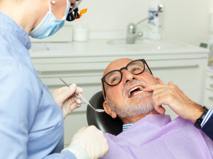 Dentist,Wearing,Surgical,Mask,And,Using,Dental,Tools,Examining,A